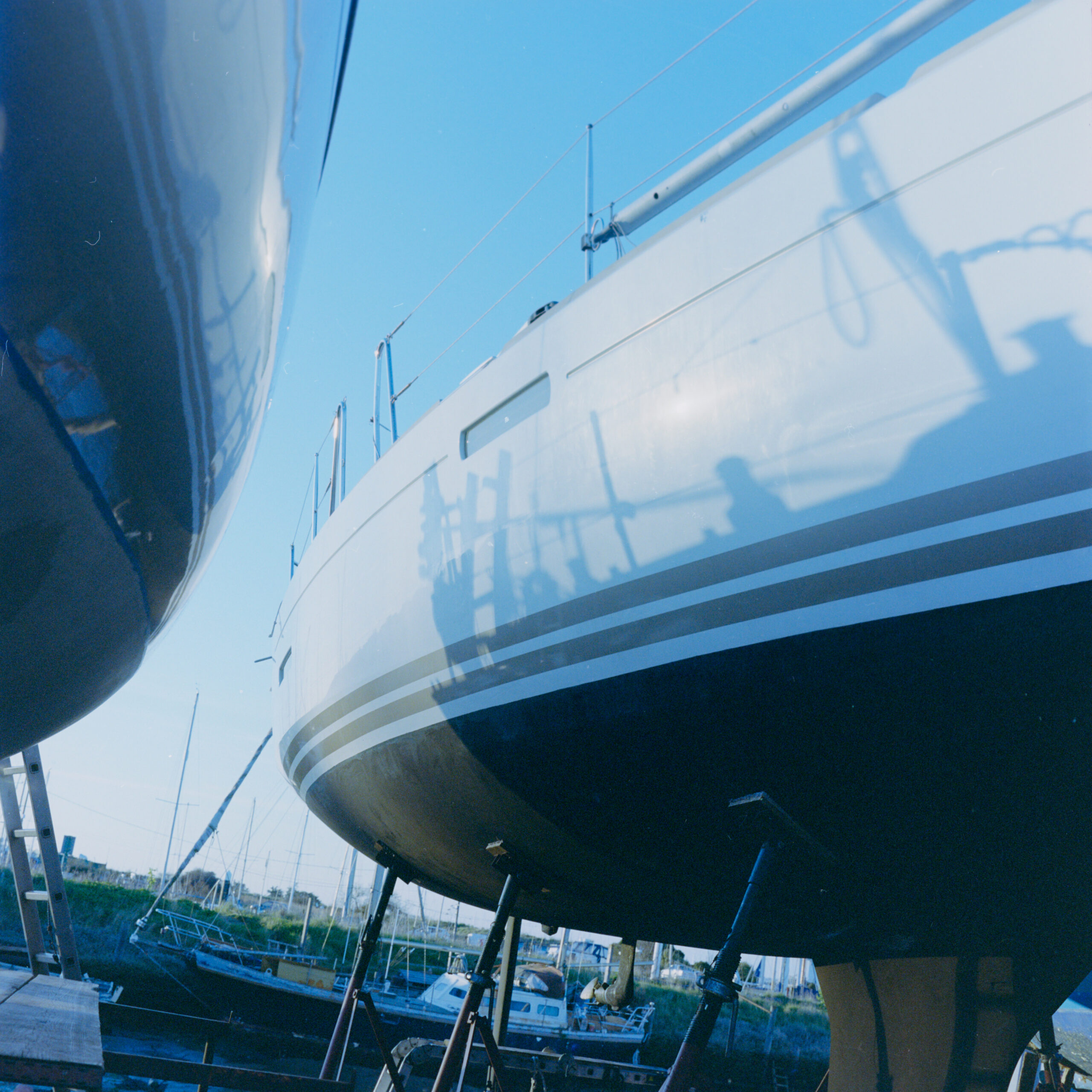 White sailboat viewed from below in a marina