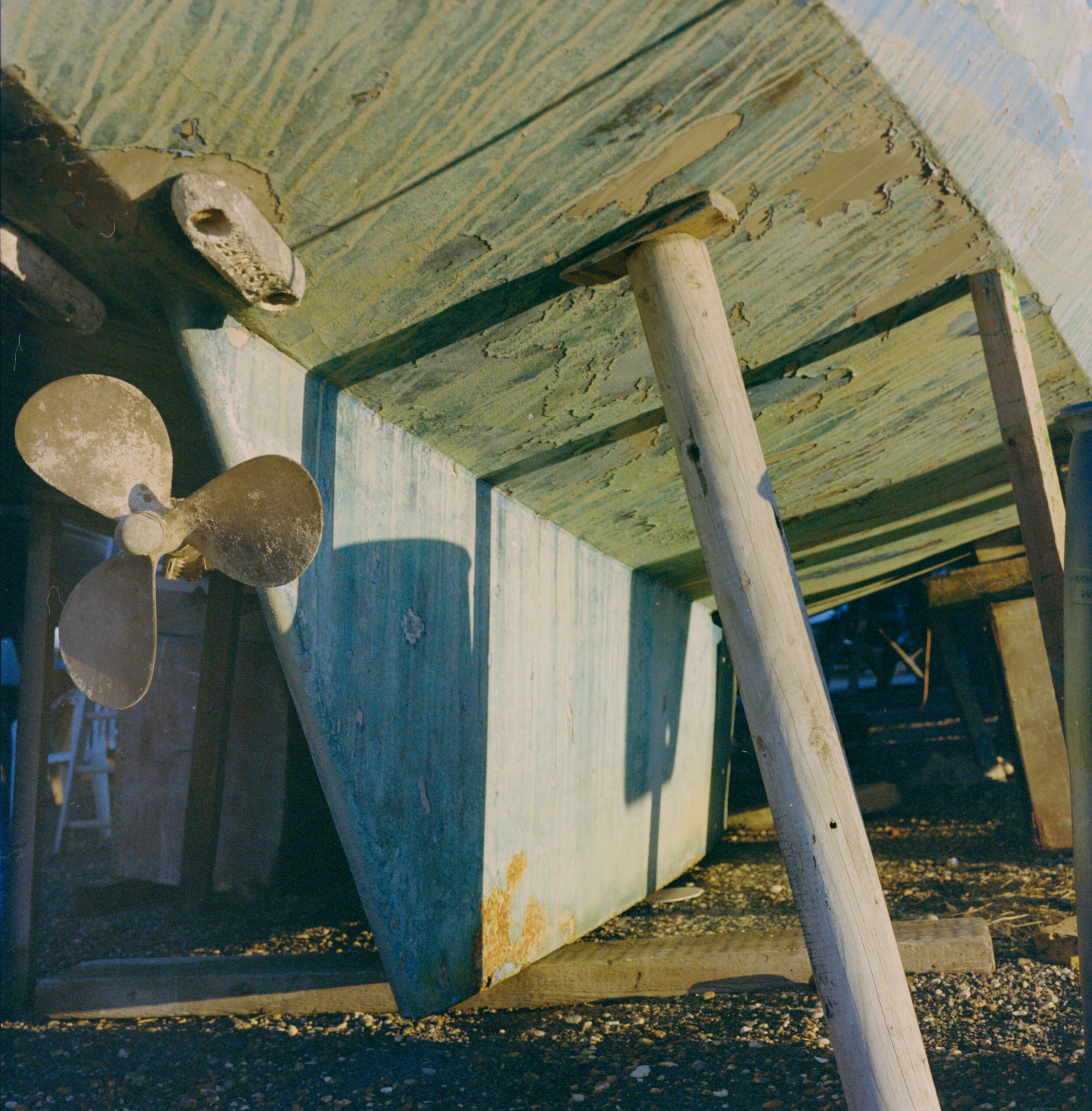 Weathered boat hull and propeller on wooden supports