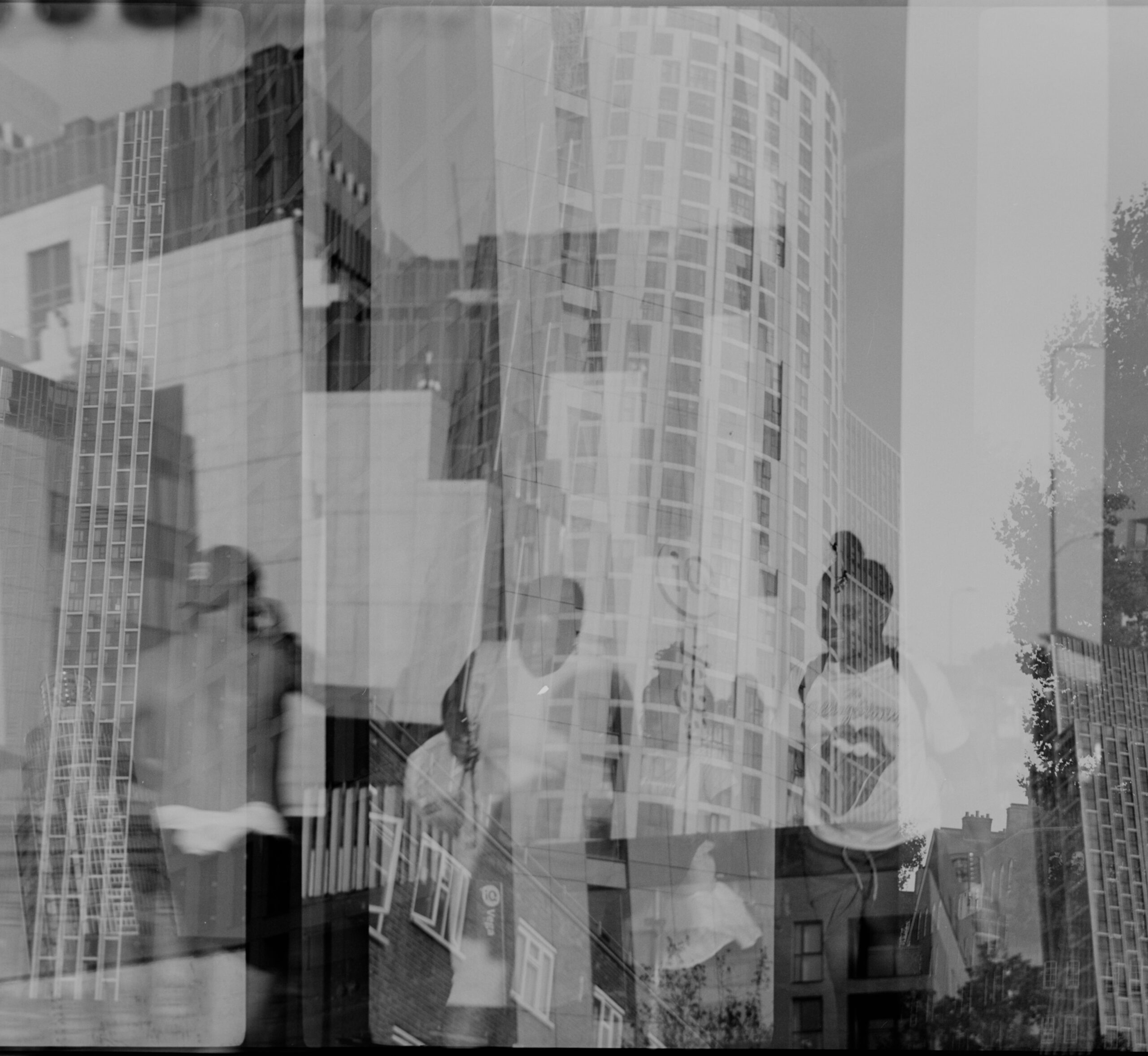 Black-and-white layered city buildings and reflected street figures