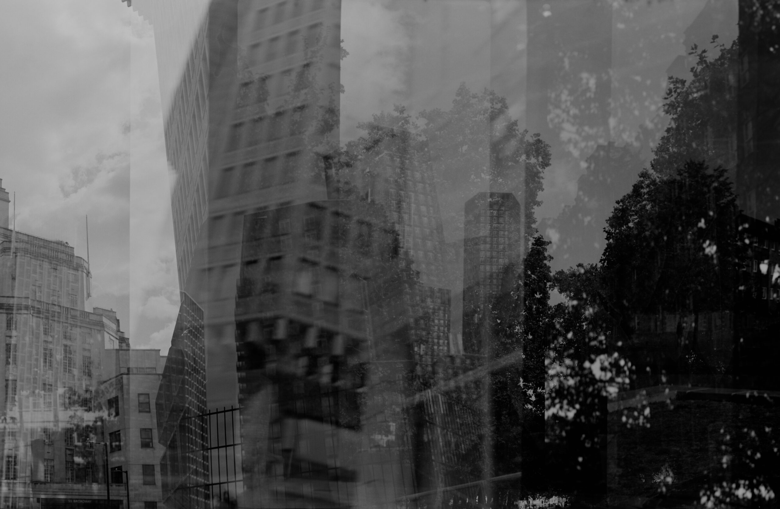 Moody monochrome composite of city buildings trees and reflections
