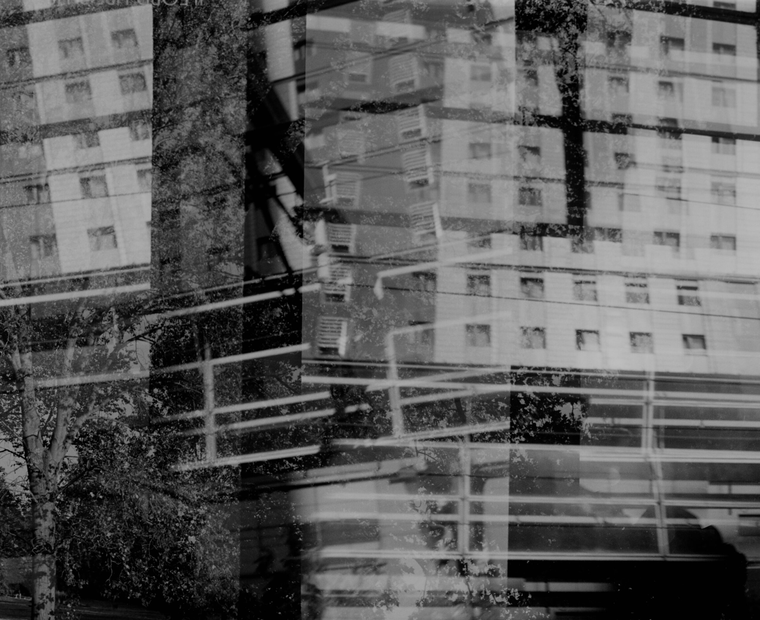 Layered reflections of apartment building trees and railings