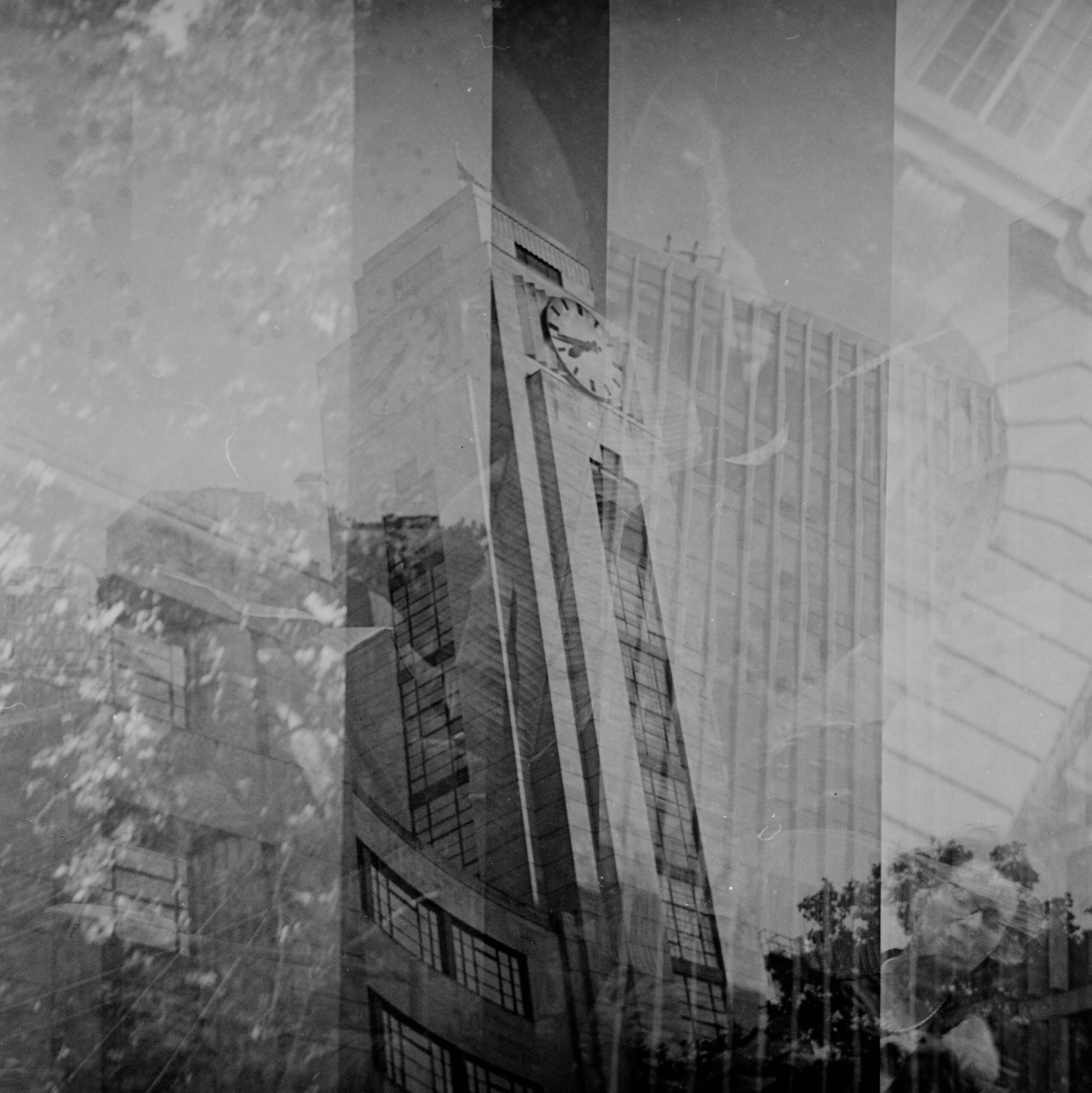 Monochrome layered photograph of a clock tower and urban reflections