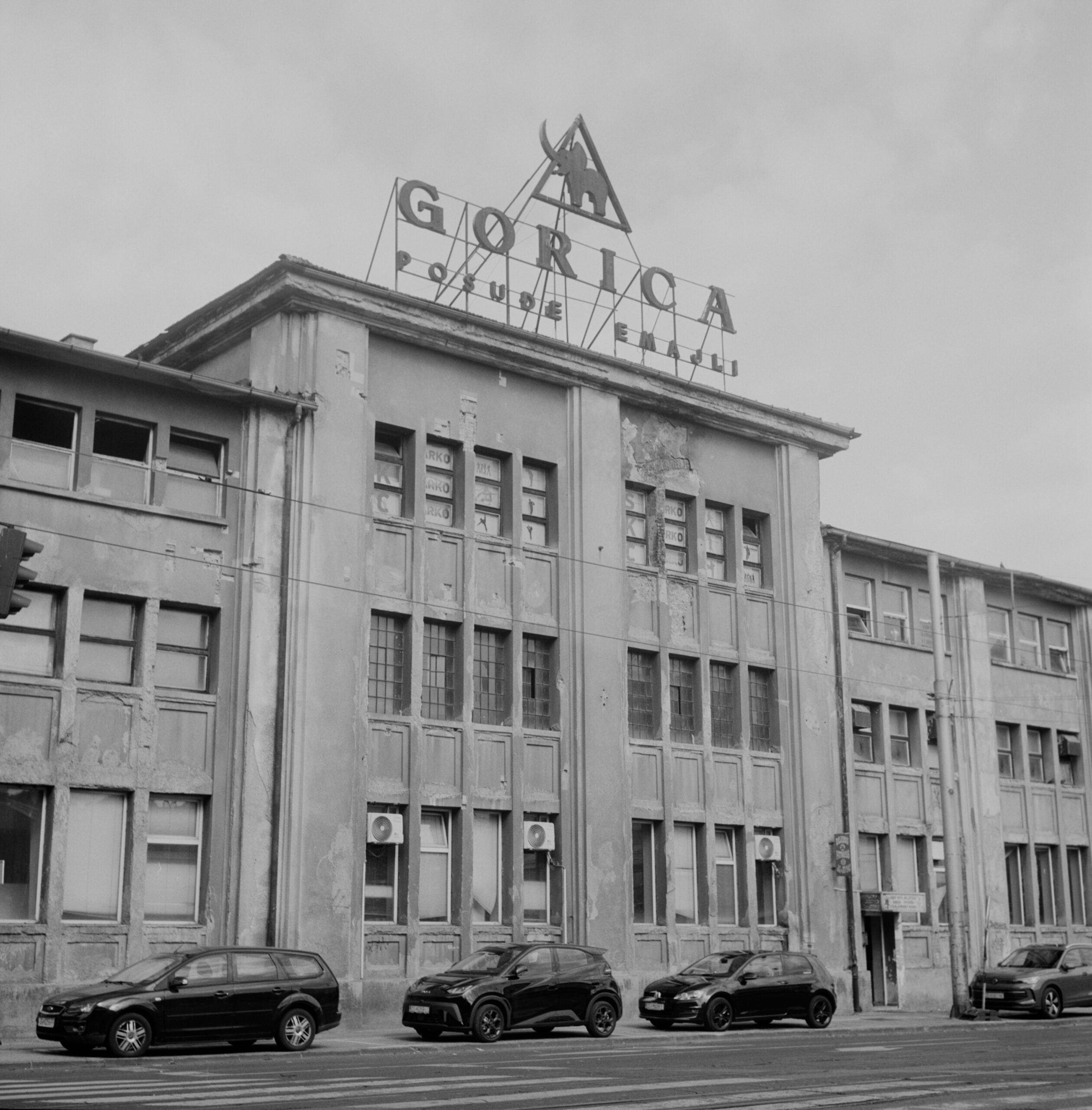 Black-and-white weathered Zagreb building with rooftop sign