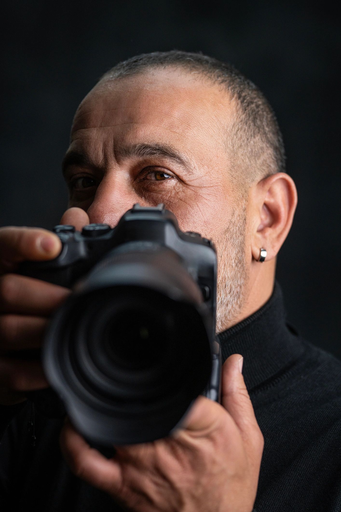 Photographer holding a camera in a studio